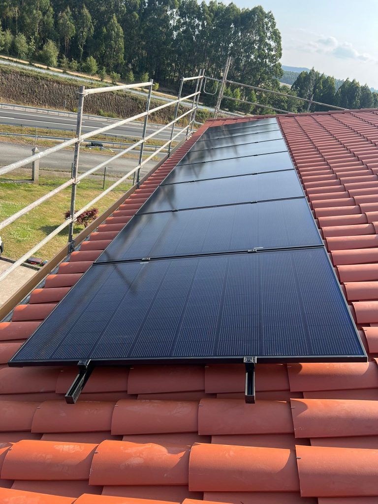 Instalación de paneles solares en tejado inclinado con tejas rojas realizada por Ximofotovoltaica con experiencia en sistemas fotovoltaicos